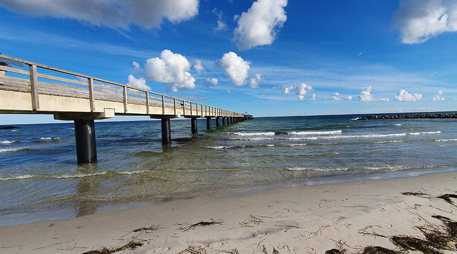 Balkon mit Tisch, Stühlen und Blick auf Ferienwohnungen